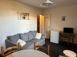 a living room with a couch and a table at Les Marguerites in Enchastrayes