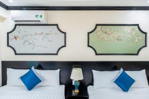 - une chambre avec 2 lits dotés d'oreillers bleus et blancs dans l'établissement Biệt Thự Gần Biển Bãi Cháy Và Bãi Marina, à Hạ Long