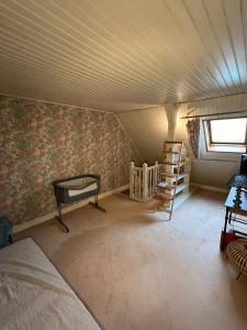 an attic room with a bed and a crib at Maison familiale avec jardin, proche Paris Centre in Neuilly-Plaisance