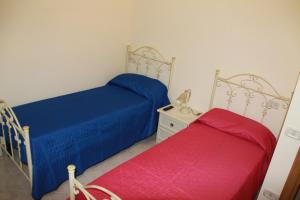 マテーラにあるCasa Vacanze Da Nicoのベッドルームにベッド2台(青と赤のシーツ付)