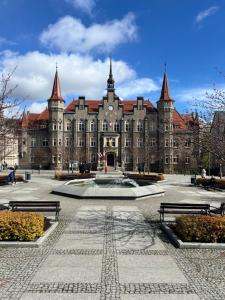 a large building with a fountain in front of it at Apartament Filmowy in Wałbrzych