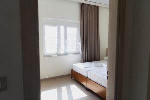 a bedroom with a bed and a window at Villa Melodia Xhek in Ksamil