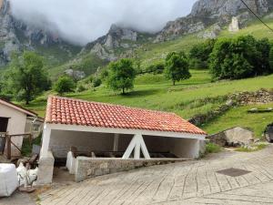 a small building with a mountain in the background at La casina de Tielve de Cabrales dentro del Parque Nacional Picos de Europa in Tielve