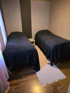 a small room with two beds and a rug at Vanha myllärin torppa in Sulkava