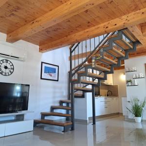 a spiral staircase in a living room with wooden ceilings at apartman "Dora" in Rogoznica