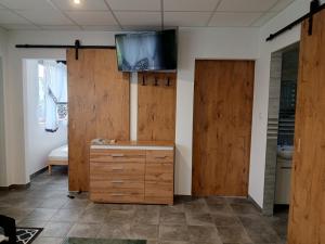 a room with wooden cabinets and a tv on the wall at Domki - Apartamenty Complex in Zator