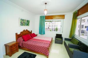a bedroom with a bed with red pillows and a window at Bright Apartment with Sea View, few steps away from the TGV in Tangier