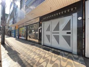 une rue vide avec une porte de garage sur un bâtiment dans l'établissement Executivo Veneza 303, à Ipatinga
