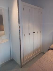 ein Schlafzimmer mit weißen Schränken neben einem Bett in der Unterkunft Bungalows Maspalomas in Maspalomas