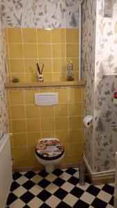 une salle de bain jaune avec des toilettes et un sol noir et blanc dans l'établissement studio 1 pièce principale avec balcon local à vélo privé place dans la rue pour voiture, à Dieppe