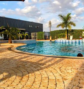 a large swimming pool with palm trees and a building at The House Beautiful, Tatu City in Tatu City