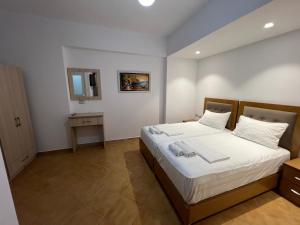 a bedroom with a large bed with white sheets at Anna Rooms in Sarandë