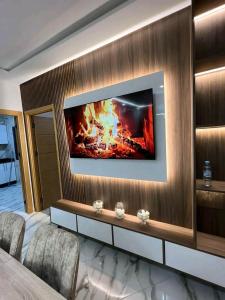 een kamer met een tv aan de muur en een open haard bij مارتيل حي احريق in Martil