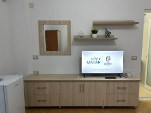 a tv sitting on top of a wooden cabinet at Anna Rooms in Sarandë