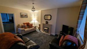 a living room with a couch and a television at No 1 Grove Road in Tow Law