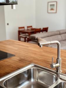 a kitchen with a sink and a living room at CHAUKA aprtamenty w centum z widokiem in Sanok +48 photos