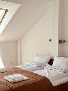 a bedroom with two beds with white sheets and a window at CHAUKA aprtamenty w centum z widokiem in Sanok
