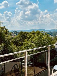 a balcony with a table and chairs and trees at CHAUKA aprtamenty w centum z widokiem in Sanok