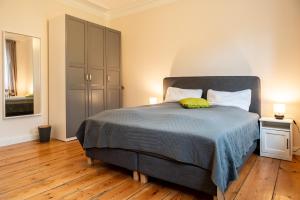 a bedroom with a bed with a blue comforter at Ferienwohnung Hafen in Schleswig