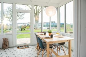 a dining room with a table and some windows at Ferienwohnung Hafen in Schleswig