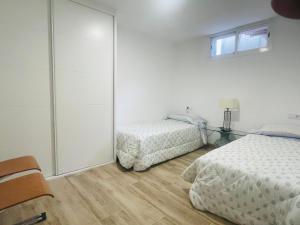 コルドバにあるLa Medina de las Floresのベッドルーム1室(ベッド2台付)、スライド式ガラスドアが備わります。