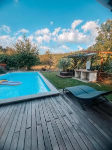 a swimming pool on a wooden deck with a table and chairs at Olive garden family apartment with private pool in Sežana