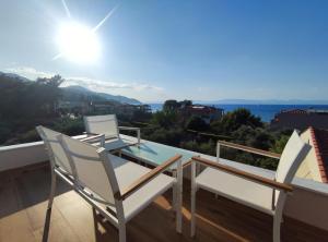 a balcony with a table and chairs on a roof at Luxury Villa Anna Marittima in Limenas
