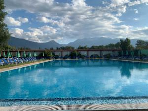 a large pool with chairs and mountains in the background at 7 apartments in Alexander complex in Bansko