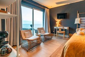 a bedroom with chairs and a room with a view of the ocean at Pedra de Lava Azores-Quarto 2 in Feteira