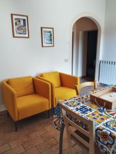 a living room with two yellow chairs and a table at Podere Chiocciola in Poggibonsi