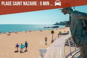 un gruppo di persone che camminano sulla spiaggia di Le cocon du désir - Balnéo et haut de gamme a Saint-Nazaire