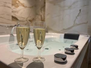 tre bicchieri di champagne seduti su una vasca da bagno di Le cocon du désir - Balnéo et haut de gamme a Saint-Nazaire