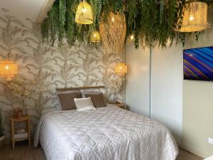 una camera con letto e alcune luci e piante di Le cocon du désir - Balnéo et haut de gamme a Saint-Nazaire