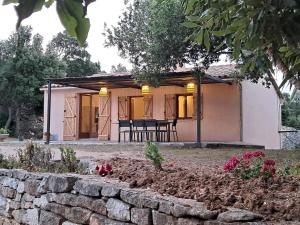 a small house with a stone wall in front of it at Maison de campagne in Bonifacio