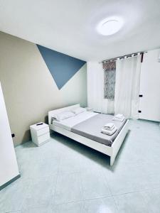 Una habitación blanca con una cama y una ventana en Home24, en Casalnuovo di Napoli