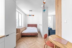 Una pequeña habitación con una cama, una mesa y sillas. en Studio w sercu Gdyni, en Gdynia