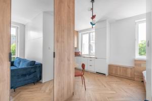 Una sala de estar con un sofá azul y una cocina. en Studio w sercu Gdyni, en Gdynia