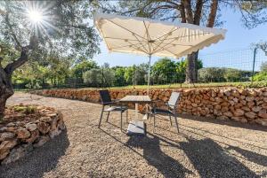 a table and two chairs under an umbrella at Villa Blanche - Suite en Provence in Draguignan