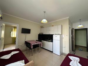a kitchen with a refrigerator and a table at Duki's Apartments in Orikum
