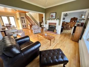 a living room with a leather couch and a fireplace at Kelly's Landing in Trinity