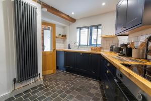 a kitchen with black cabinets and a sink at Stylish Home near Alton Towers Peak District Ashbourne Derbyshire in Ashbourne