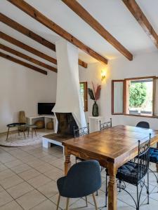 a living room with a wooden table and a fireplace at Maison de campagne in Bonifacio