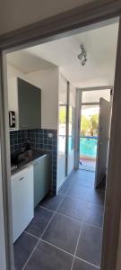 eine Küche mit Spüle und Fliesenboden in der Unterkunft Studio - La Grande Motte in La Grande-Motte