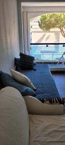 ein Schlafzimmer mit einem Bett mit Kissen und einem Fenster in der Unterkunft Studio - La Grande Motte in La Grande-Motte