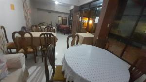 a dining room with a white table and chairs at Hostal Edén in Torotoro