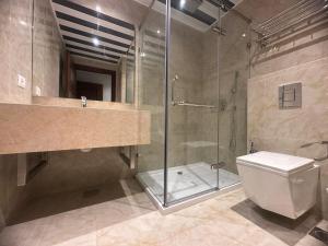 a bathroom with a glass shower and a toilet at 365 UrbanLiving in Jbeil