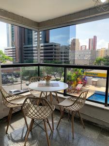un tavolo e sedie su un balcone con vista sulla città di Via Venetto Feirinha Beira Mar a Fortaleza