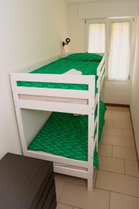 a bedroom with a bunk bed with green sheets at Casa Giorgiotto in Lido di Jesolo