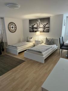 ein Schlafzimmer mit zwei Betten und einer Uhr an der Wand in der Unterkunft By Stelwag in Bermatingen
