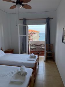 a room with two beds and a table with a view at Evangelia Studios in Sígrion